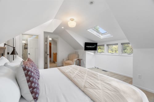 Your bright attic bedroom offers cozy comfort with natural light streaming through skylights and windows, creating a perfect retreat.